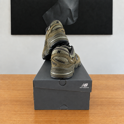 New Balance M1000 NBU : boîte et chaussures centrées sous le tableau noir, sans étiquette blanche