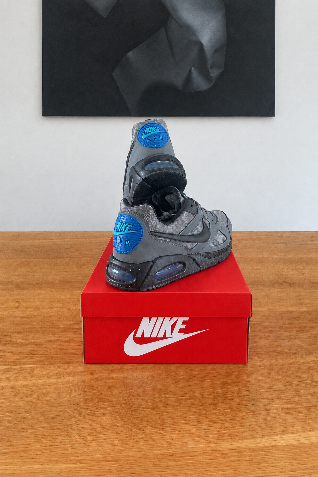 Version retouchée générée de la deuxième vue des Nike Air Max IVO, boîte rouge NIKE centrée sous le tableau noir