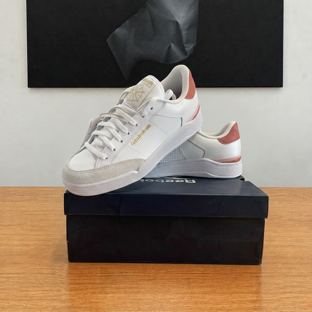 Reebok blanches et roses, vue diagonale sur boîte recentrée au cadrage carré Shox
