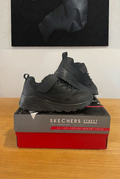 Skechers 403651L noires sur boîte centrée sous tableau vue de face, image retouchée