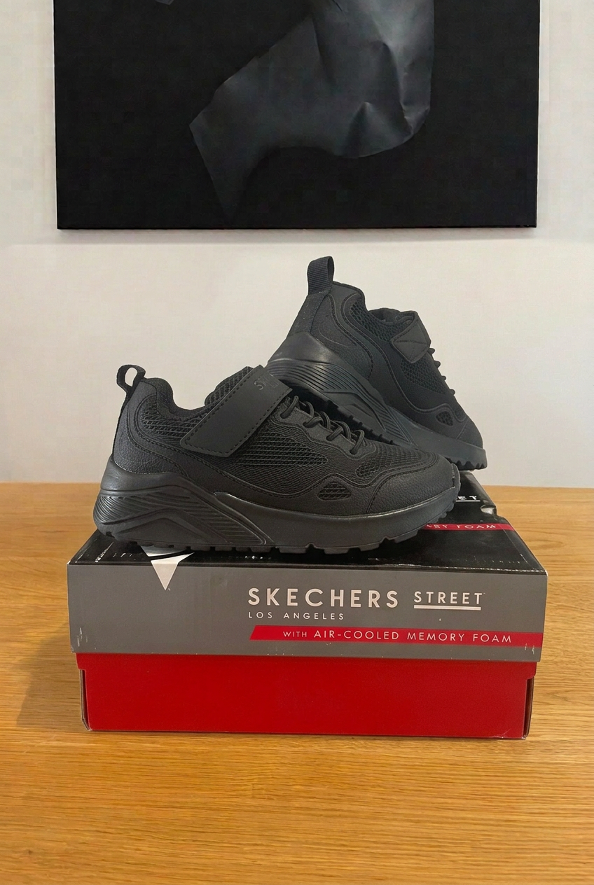 Skechers 403651L noires sur boîte centrée sous tableau vue de face, image retouchée