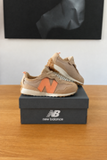 New Balance NW327WO enfants de profil sur boîte recentrée avec logo New Balance