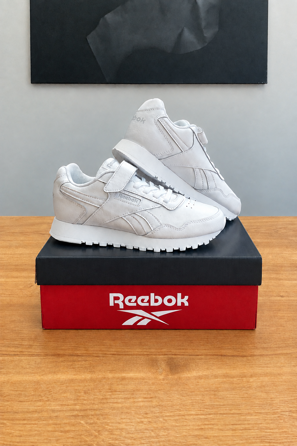 Version retouchée générée de la première vue, marquage Reebok stylisé sur la boîte, centrée sous le tableau noir