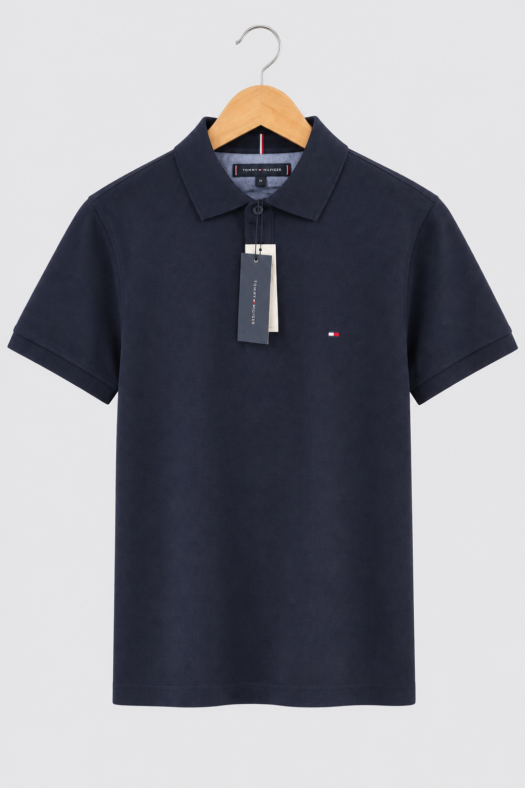 Polo Tommy Hilfiger bleu nuit avec étiquettes sur fond clair