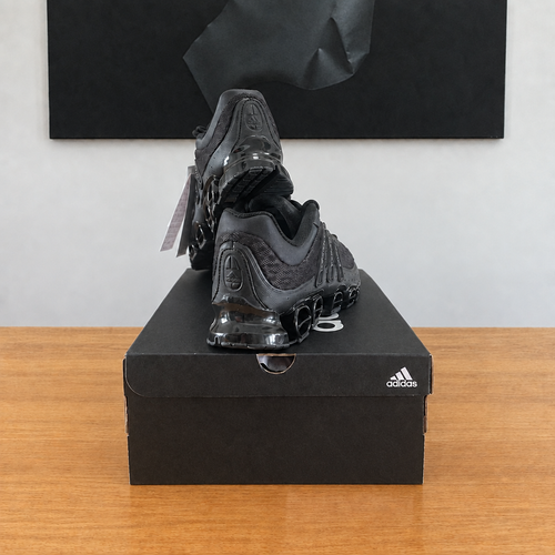 Adidas Megaride : boîte et chaussures centrées sous le tableau noir, sans étiquette blanche