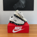 NIKE AIR MAX SHOX TL : boîte et chaussures centrées sous le tableau noir