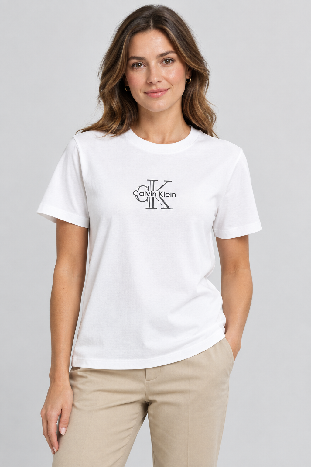 Femme portant le t-shirt Calvin Klein blanc avec un pantalon beige