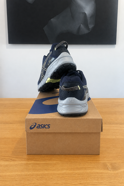 Asics Gel Venture 10 vues de dos sur boîte recentrée sans étiquettes, tableau en arrière-plan