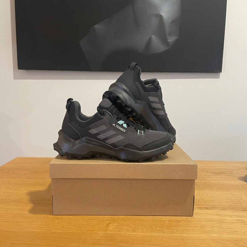 Adidas Terrex noires sur boîte centrée, photo retouchée