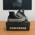 Converse Chuck Taylor noires sur boîte centrée, photo retouchée