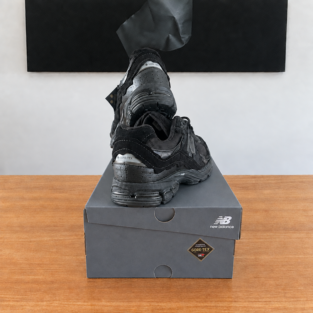 New Balance U2002 : boîte et chaussures centrées sous le tableau noir, sans étiquette blanche