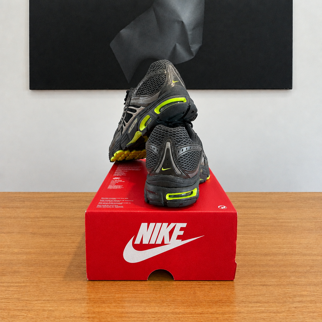 NIKE AIR MAX MOTO 2K : boîte et chaussures centrées sous le tableau noir