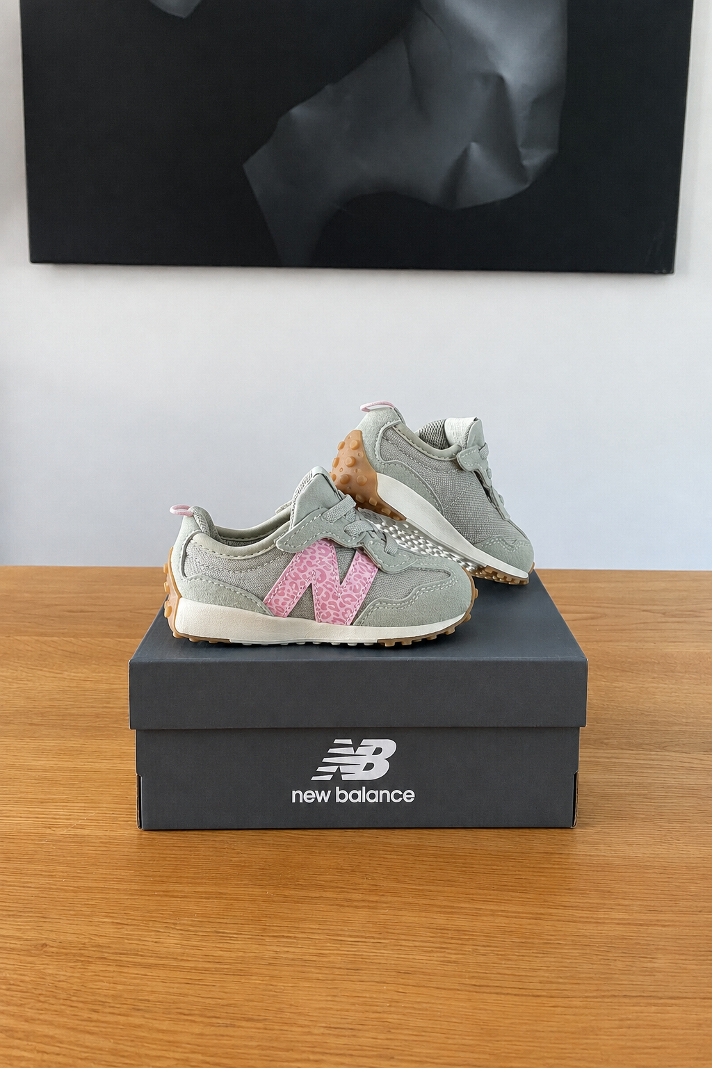 New Balance NW327WT de profil sur boîte recentrée avec logo