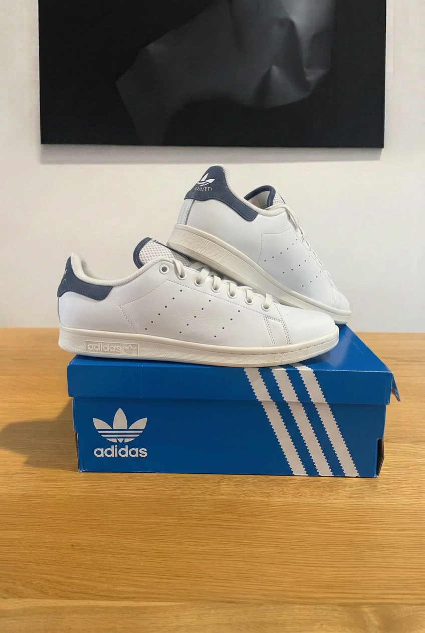 Adidas Stan Smith sur boîte bleue, cadrage rapproché sous tableau comme annonce précédente, photo retouchée