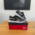 Reebok Court Advance noir et argenté avec logo Reebok blanc sur la face avant de la boîte