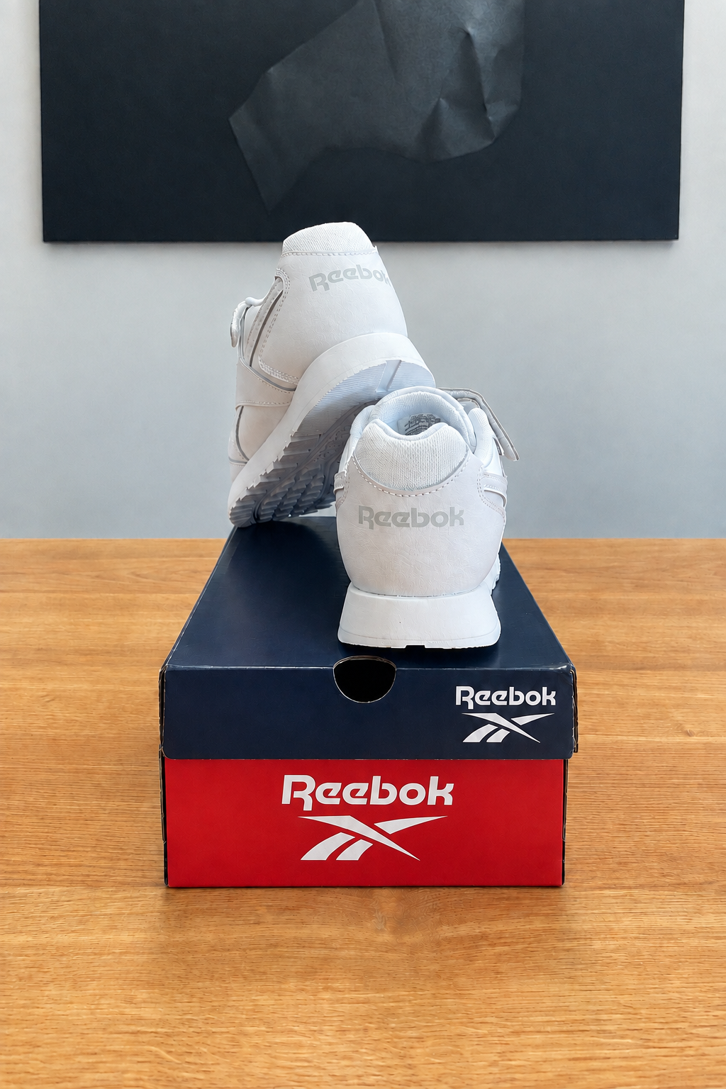 Version retouchée générée de la deuxième vue, boîte sans étiquette et marquage Reebok stylisé, centrée sous le tableau noir