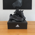 Adidas Megaride : boîte et chaussures centrées sous le tableau noir