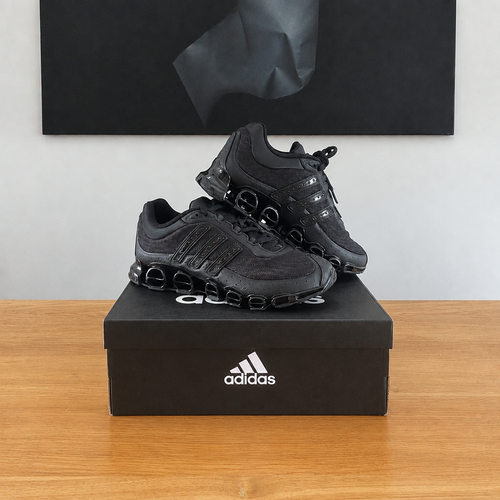 Adidas Megaride : boîte et chaussures centrées sous le tableau noir
